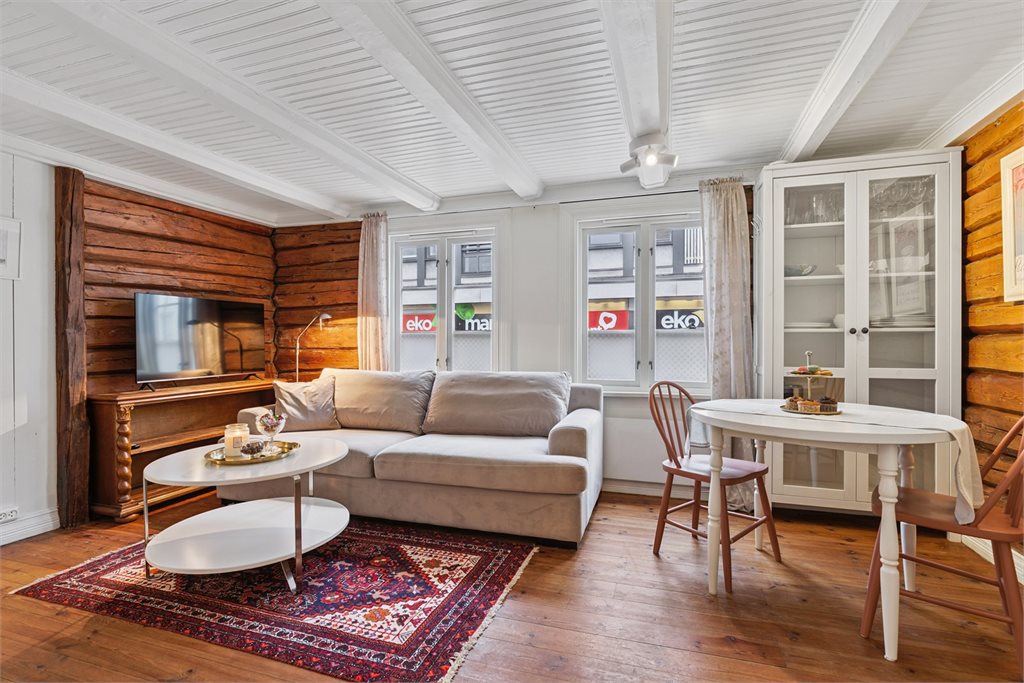 Det er originale tømmervegger som gir en meget lun hjemmekoselig
 følelse i stua.