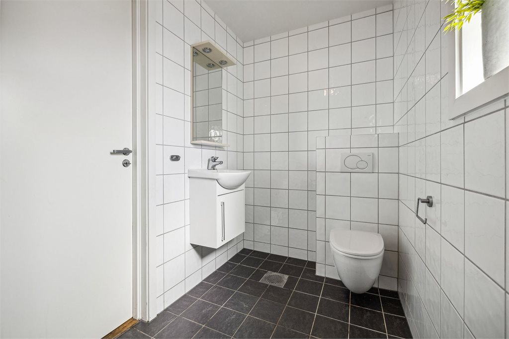 Gjestetoalett i 1. etasje som er helfliset med varmekabler i gulv. Her er det innredet med veggehengt toalett
og vask i seksjon.