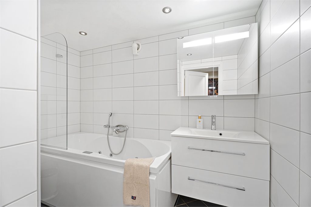 Badet i denne etasjen er innredet med badekar, toalett og servant m/speil. 