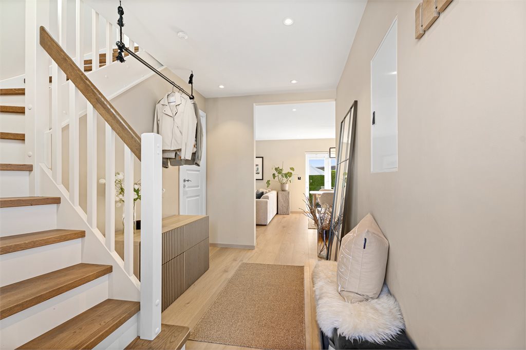 Her blir du ønsket velkommen inn en lys og innbydende entré med god plass til å henge fra seg yttertøyet. 