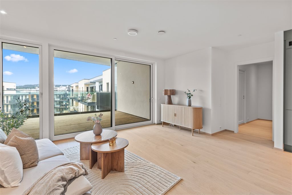 Lys, pen og romslig stue med utgang til balkong.